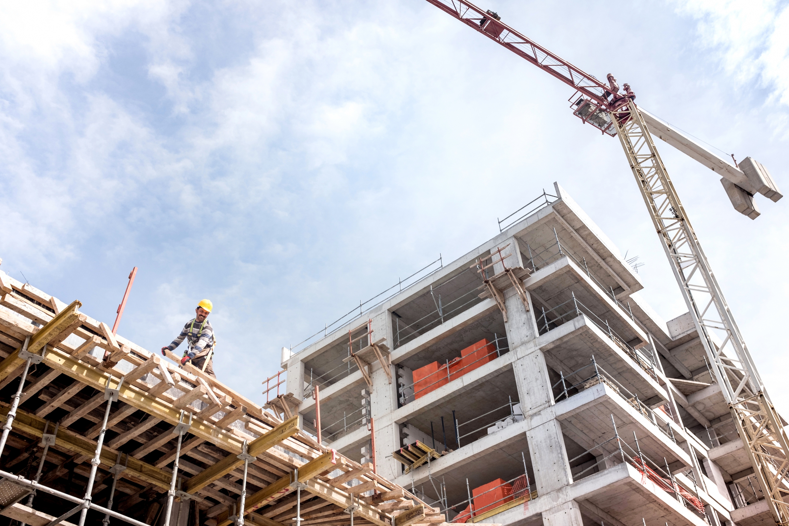specialist working on top of building with a tower crane